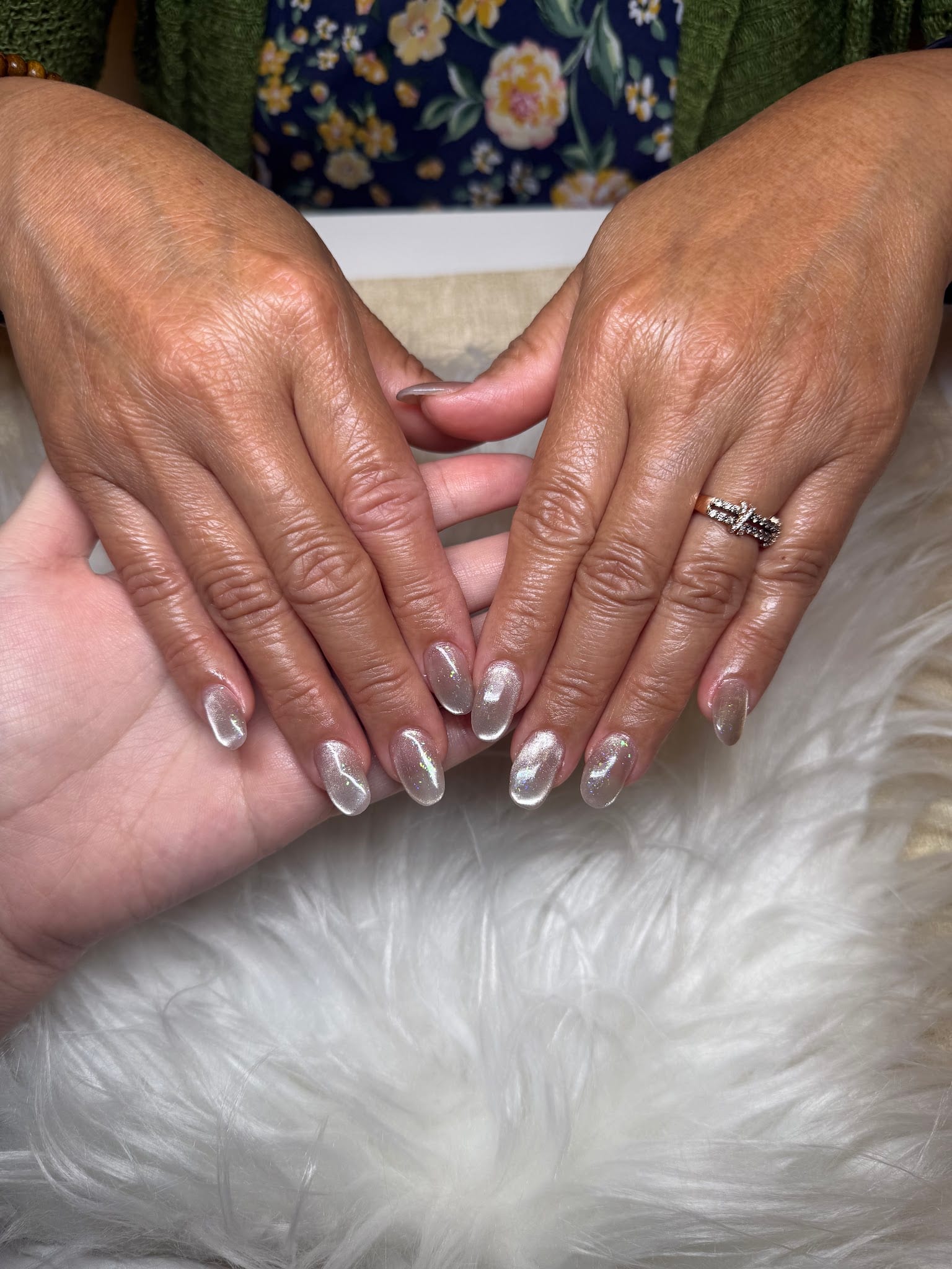 Hands with pearlescent shimmer gel manicure on almond-shaped nails