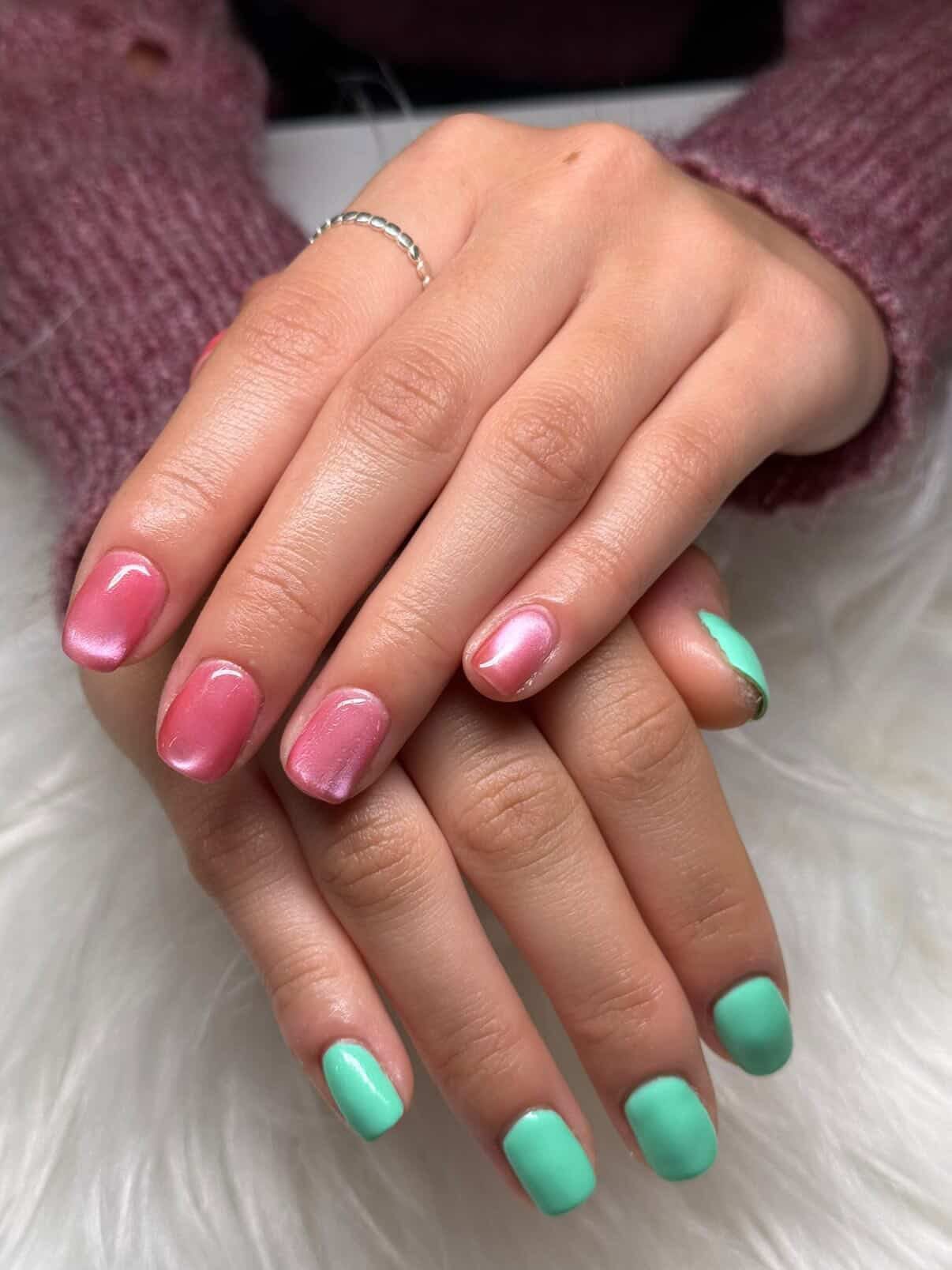 Two hands with short pink and mint green gel polish nails