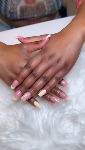 Two hands displaying long pink and white French manicure acrylic nails