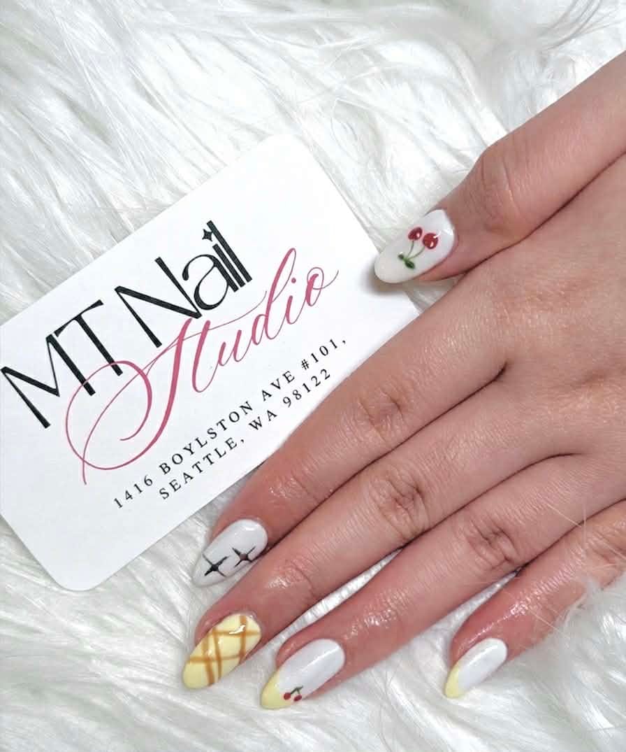 White almond nails with cherry, star, and waffle nail art designs