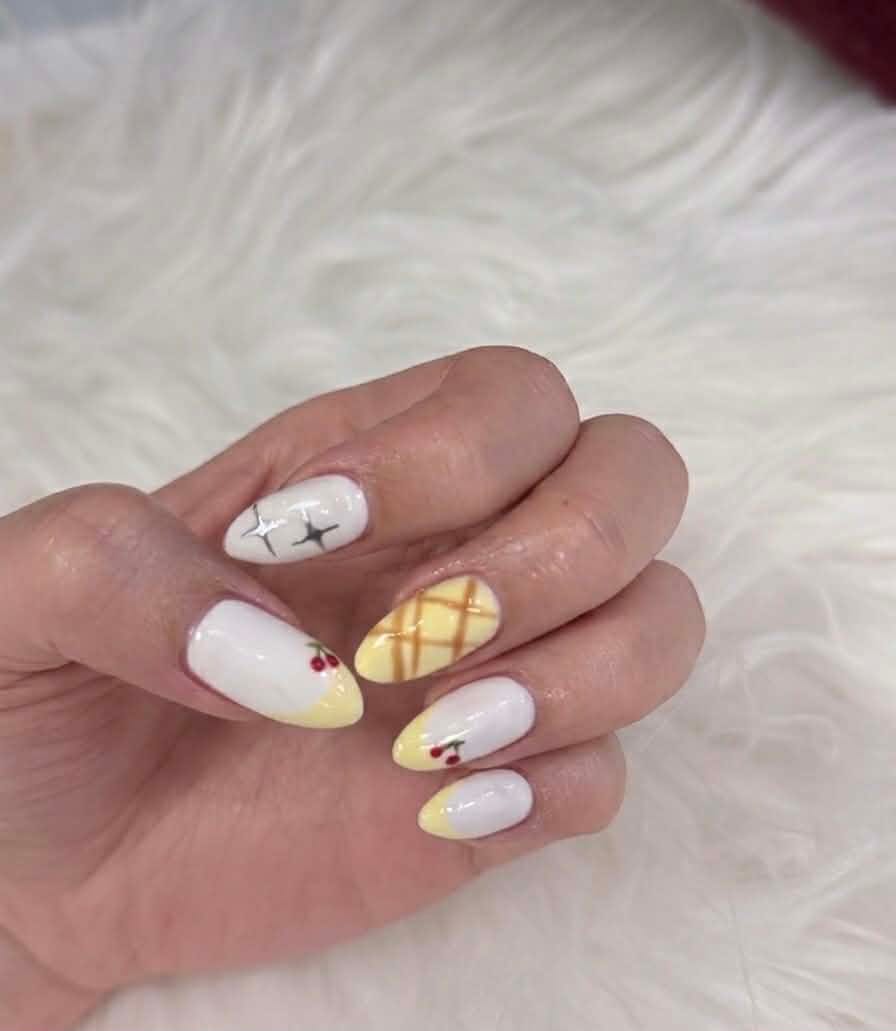 Almond nails with white base, yellow plaid, cherries, and star art